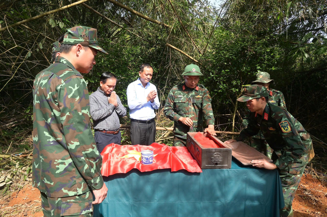 Các đại biểu cùng người dân và lực lượng chức năng làm lễ trước khi tiến hành cất bốc 28 hài cốt liệt sĩ. (Ảnh: Nguyễn Hải)