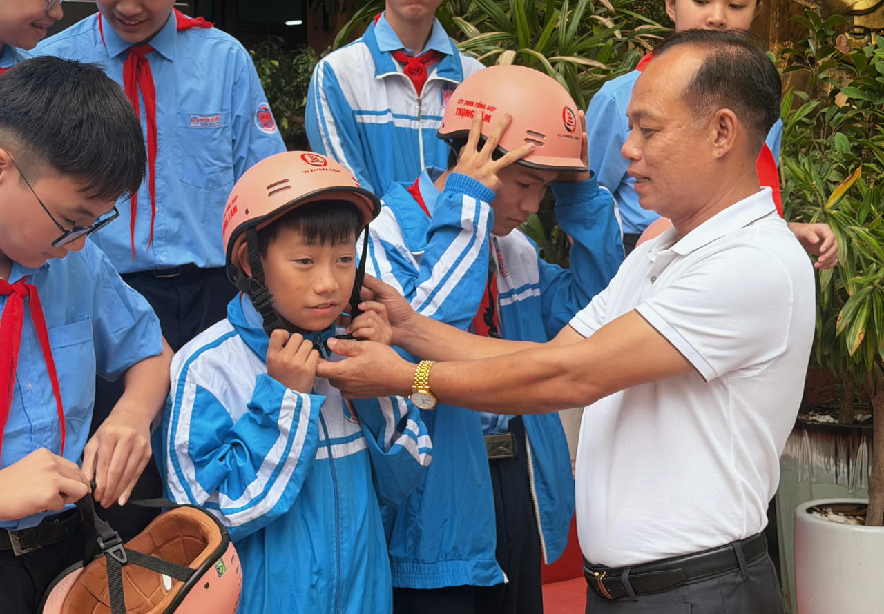 Nhà báo Nguyễn Quang Tám, Trưởng Văn phòng đại diện Báo Pháp luật Việt Nam tại TP Đà Nẵng trao mũ bảo hiểm cho học sinh.
