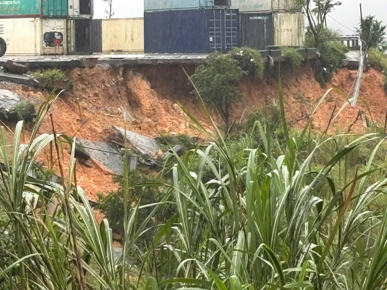 Đất đá tại khu vực Bãi Kiểm hóa bị sạt trượt, tạo thành vệt sạt lớn dưới khu vực đặt các container. (Ảnh: UBND xã Dân Hóa)