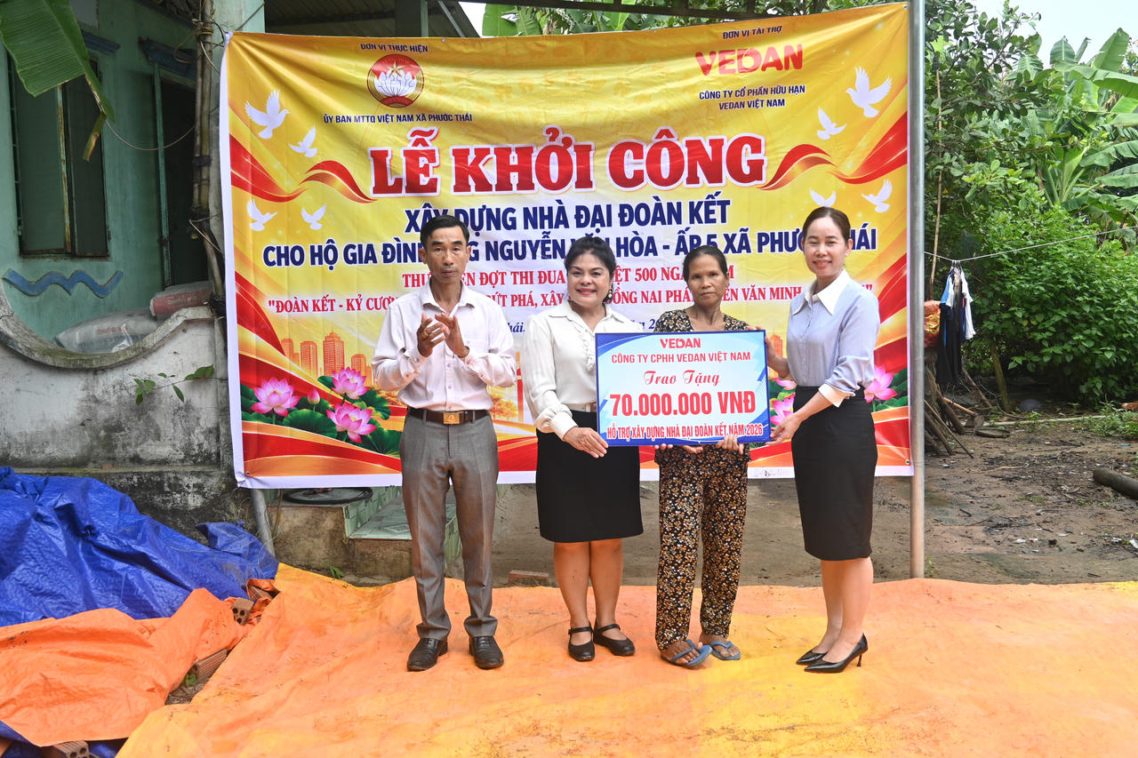 Bà Nguyễn Thu Thủy - Phó Giám đốc Đối ngoại Vedan Việt Nam (áo trắng) trao tặng nhà Đại đoàn kết cho gia đình ông Nguyễn Văn Hòa.