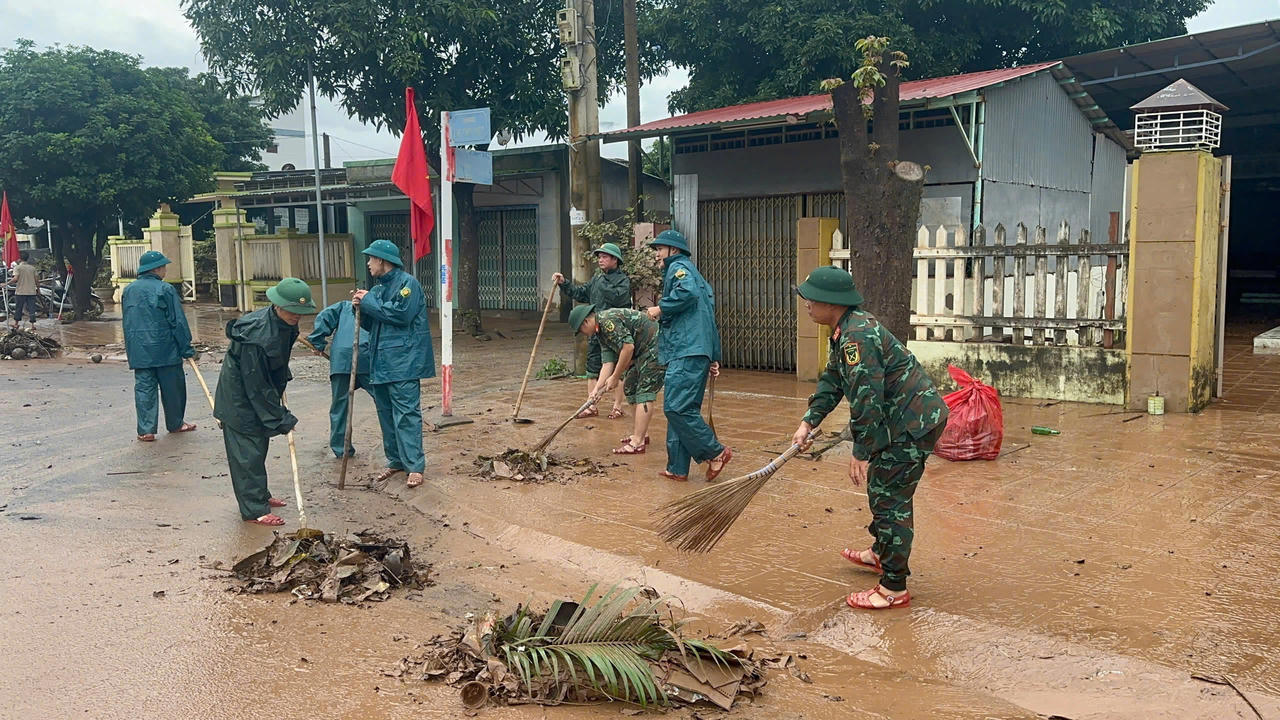 Lực lượng vũ trang Quảng Trị cùng người dân thu gom rác thải, bùn đất trên các tuyến đường, khẩn trương khắc phục hậu quả mưa lũ. (Ảnh: X.D)