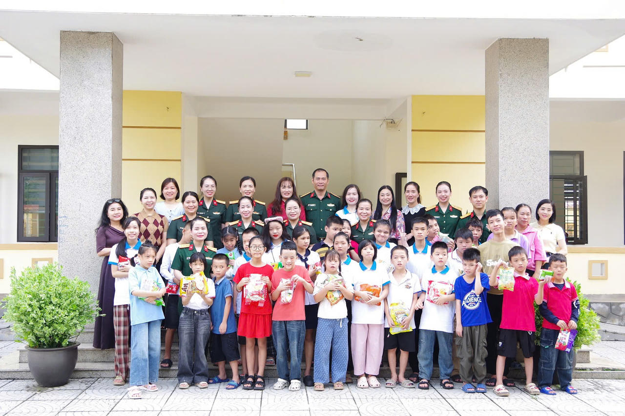 Đoàn công tác Bộ CHQS tỉnh Quảng Trị chụp ảnh lưu niệm cùng cán bộ, giáo viên và học sinh Trường Giáo dục chuyên biệt Đồng Hới. (Ảnh: Xuân Diện)