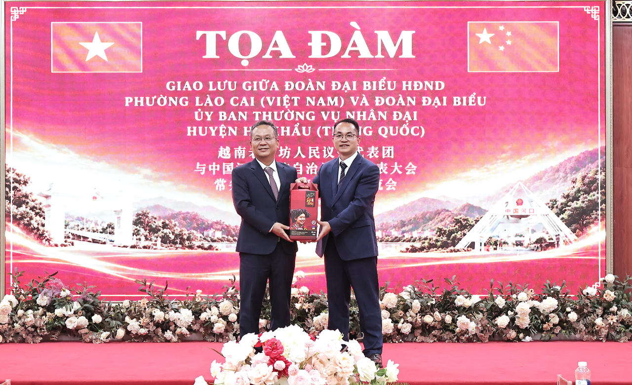 Bí thư Đảng ủy, Chủ tịch HĐND phường Lào Cai tặng quà Đoàn đại biểu Ủy ban Thường vụ Đại hội đại biểu nhân dân huyện tự trị dân tộc Dao Hà Khẩu, tỉnh Vân Nam (Trung Quốc) (Ảnh: Hữu Trường).