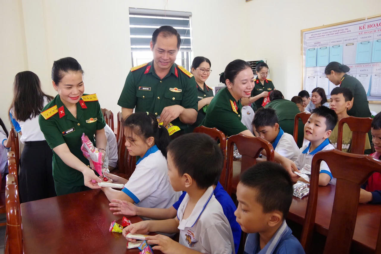 Cán bộ, chiến sĩ Bộ CHQS tỉnh Quảng Trị trao những phần quà Trung thu đến các em học sinh. (Ảnh: Xuân Diện)
