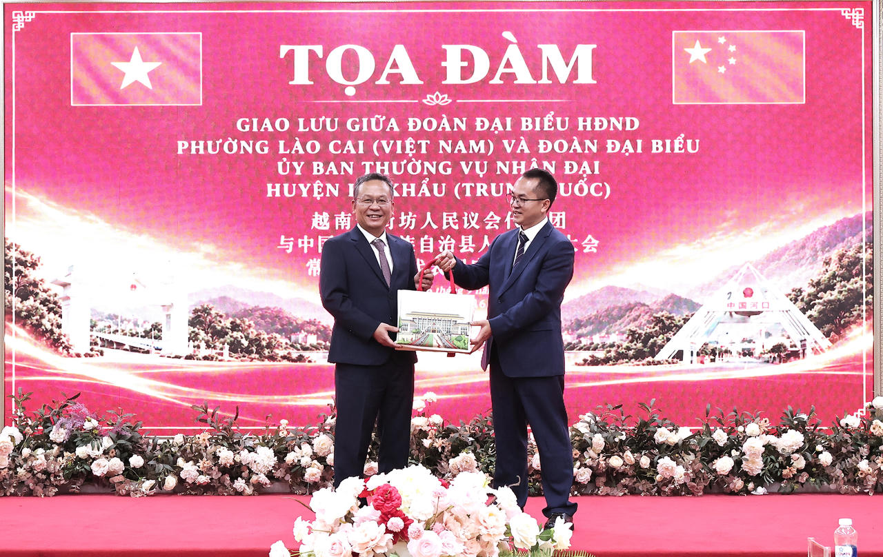 Ông Lý Khai Tường - Bí thư Tổ Đảng, Chủ nhiệm Ủy ban Thường vụ Đại hội đại biểu nhân dân huyện tự trị dân tộc Dao Hà Khẩu tặng quà cho lãnh đạo phường Lào Cai (Ảnh: Hữu Trường).