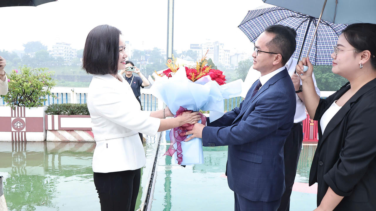 Bà Trần Thị Nguyệt, Phó Chủ tịch HĐND phường Lào Cai tặng hoa đón đoàn đại biểu huyện Hà Khẩu (Trung Quốc). (Ảnh: Hữu Trường).