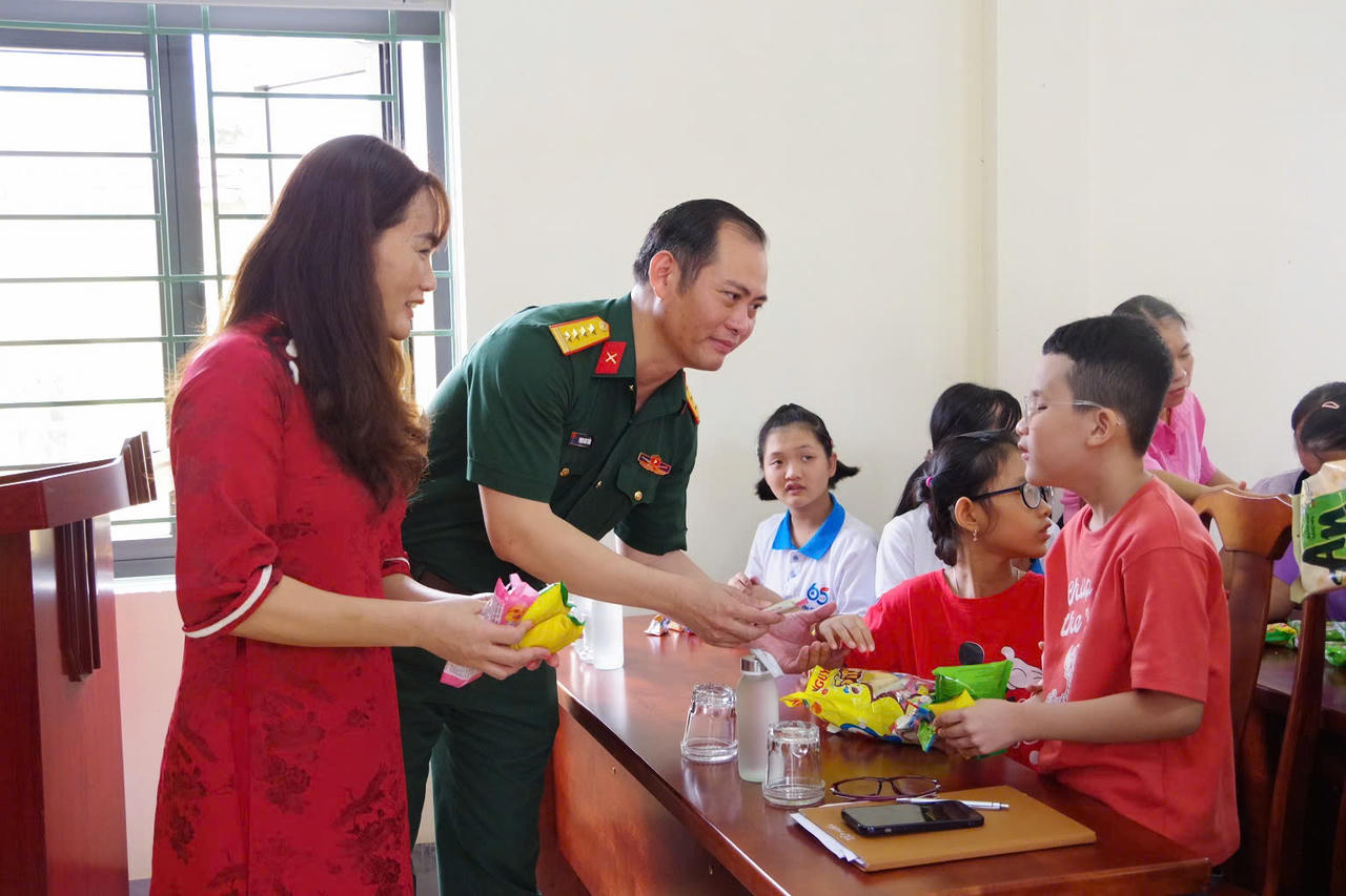 Đại tá Phạm Anh Tuấn, Phó Chủ nhiệm Chính trị Bộ CHQS tỉnh, thăm hỏi, tặng quà các em học sinh trường chuyên biệt Đồng Hới. (Ảnh: Xuân Diện)