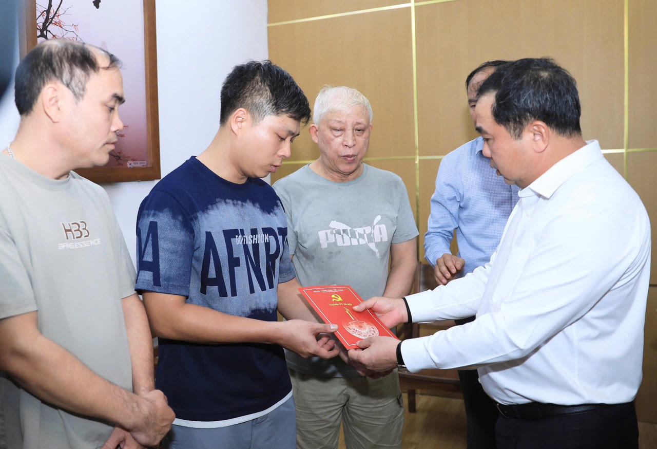 Bí thư Thành ủy Hà Nội Trần Đức Thắng cùng đoàn công tác trao tiền hỗ trợ cho gia đình các nạn nhân trong vụ cháy. Ảnh: Quang Thái
