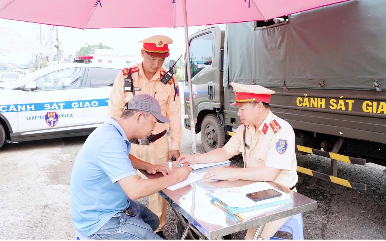 Cán bộ, chiến sĩ CSGT tuyên truyền, nhắc nhở người điều khiển phương tiện nâng cao ý thức chấp hành quy định khi tham gia giao thông. Ảnh: Hiên Thanh