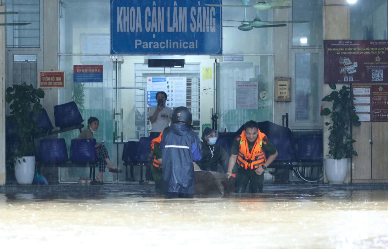 Công an phường Hoàng Mai dùng thuyền hỗ trợ bệnh nhân và người nhà di chuyển (Ảnh CSCC)