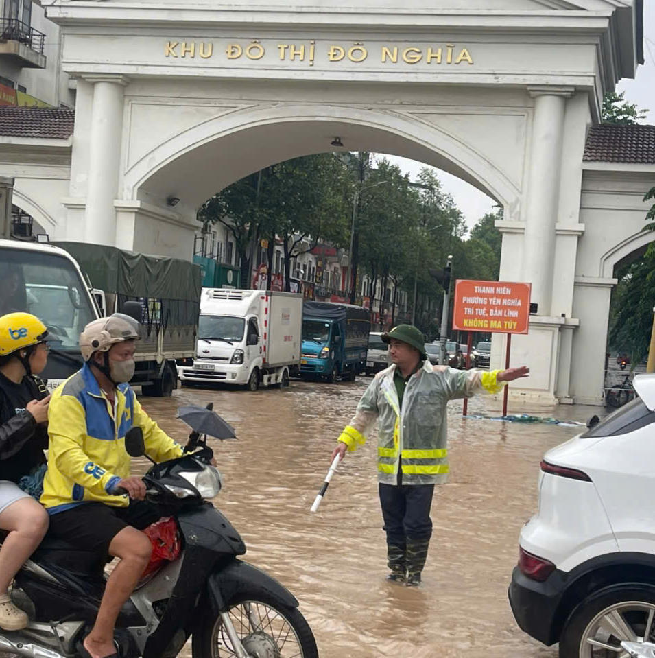 Công an phường Yên Nghĩa phân luồng giao thông cho các phương tiện  tránh điểm ngập úng.