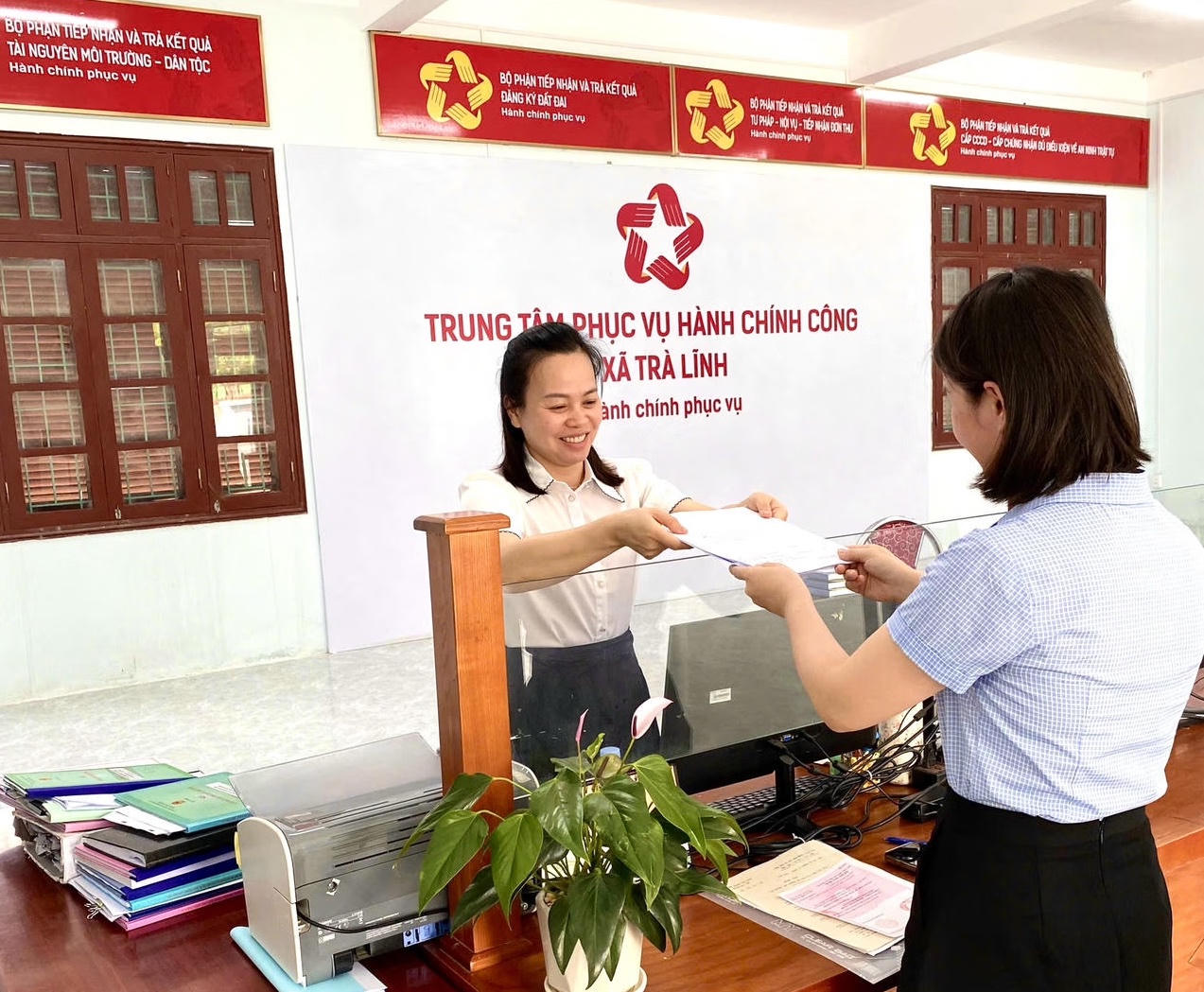 Cán bộ Trung tâm hành chính công xã Trà Lĩnh (Cao Bằng) hỗ trợ giúp người dân đến đến làm thủ tục cấp bản sao trích lục hộ tịch. (Ảnh: Lê Hanh)