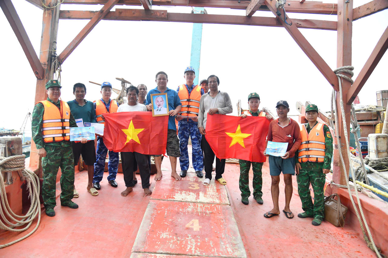 Bộ Tư lệnh Vùng Cảnh sát biển 4 tuyên truyền pháp luật, tặng cờ Tổ quốc, ảnh Bác Hồ và áo phao cứu sinh cho ngư dân đang khai thác hải sản trên biển. Ảnh: Đức Thái