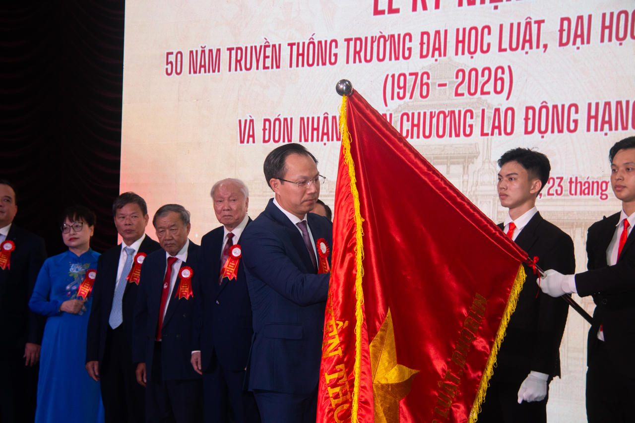 Thứ trưởng Bộ Giáo dục và Đào tạo Đoàn Trung Kiên gắn Huân chương Lao động hạng Nhất lên lá cờ truyền thống của Nhà trường.