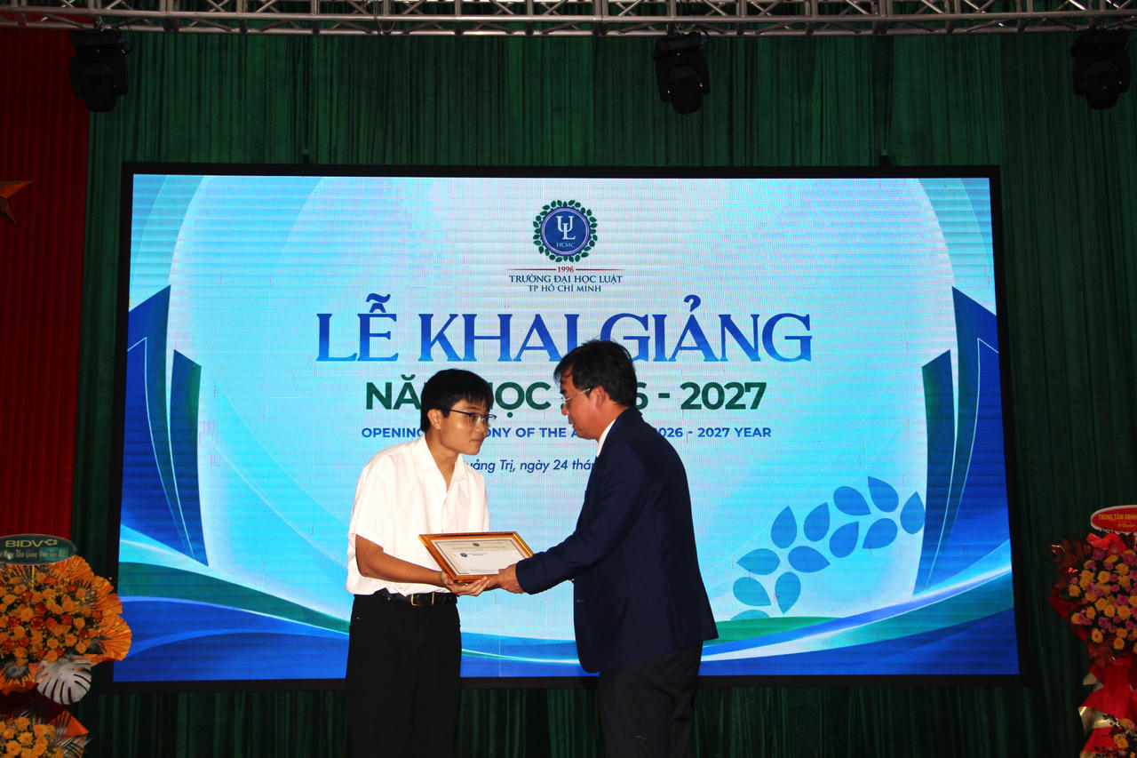 TS Lê Trường Sơn, Hiệu trưởng Trường Đại học Luật TP Hồ Chí Minh trao giấy khen, chúc mừng Nguyễn Vũ Nguyên, thủ khoa đầu vào Khóa 51. (Ảnh: M.P)