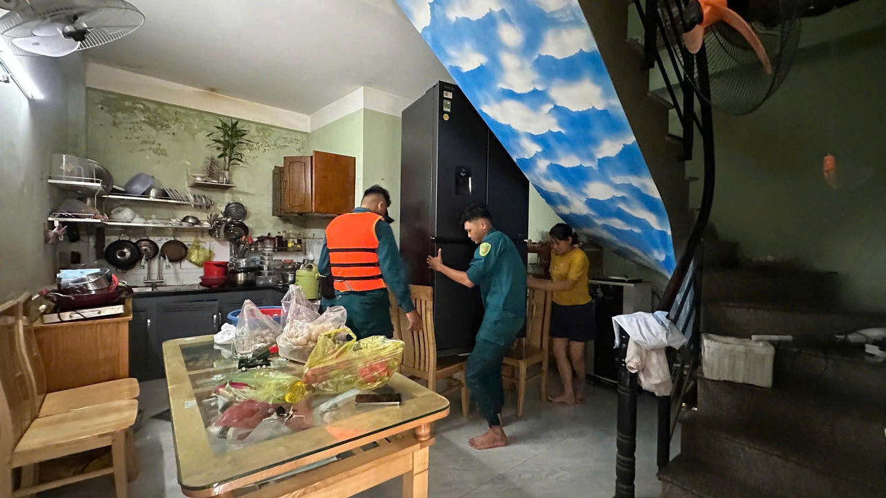 Lực lượng chức năng hỗ trợ người dân khu phố Hương Phước kê cao tài sản để hạn chế thiệt hại khi nước tiếp tục dâng. Ảnh: DK