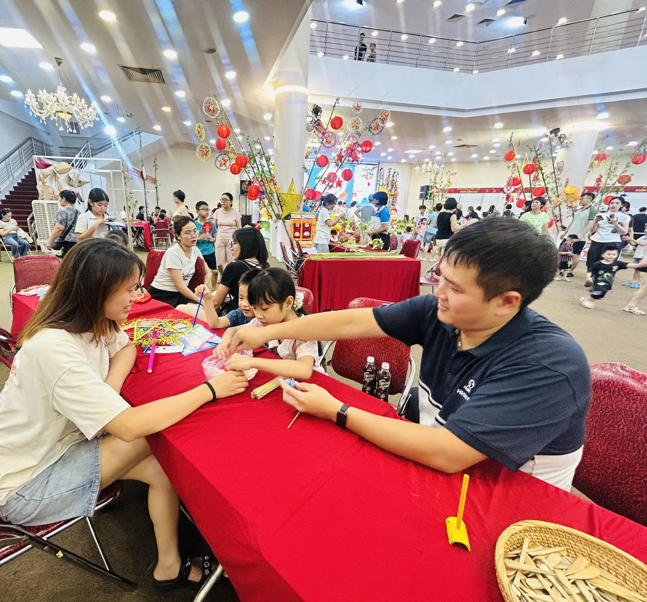 Cha mẹ hướng dẫn các con làm đèn ông sao (Ảnh: Thùy Dương)