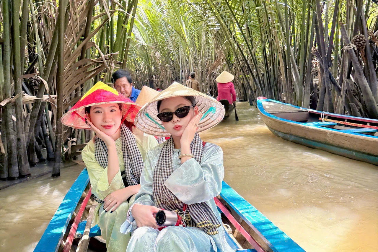 Khách du lịch "check - in" cồn Thới Sơn, ngồi trên xuồng len lỏi qua các rạch dừa nước. Ảnh: Ngọc Hân