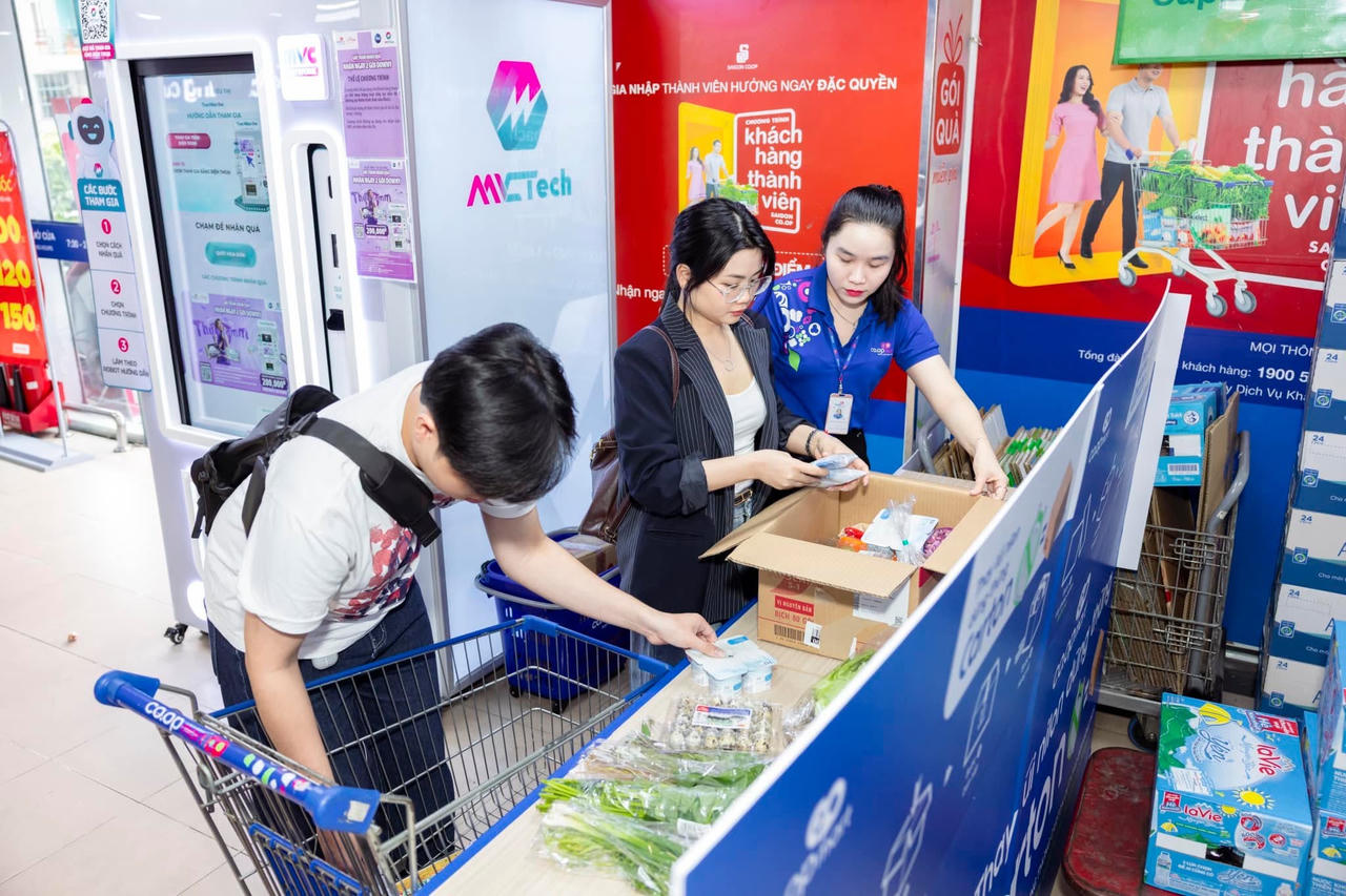Nhân viên Co.opmart hướng dẫn khách hàng quy cách thực hiện đóng gói bằng thùng carton thể hiện hành động xanh bảo vệ môi trường. Ảnh: Saigon Co.op