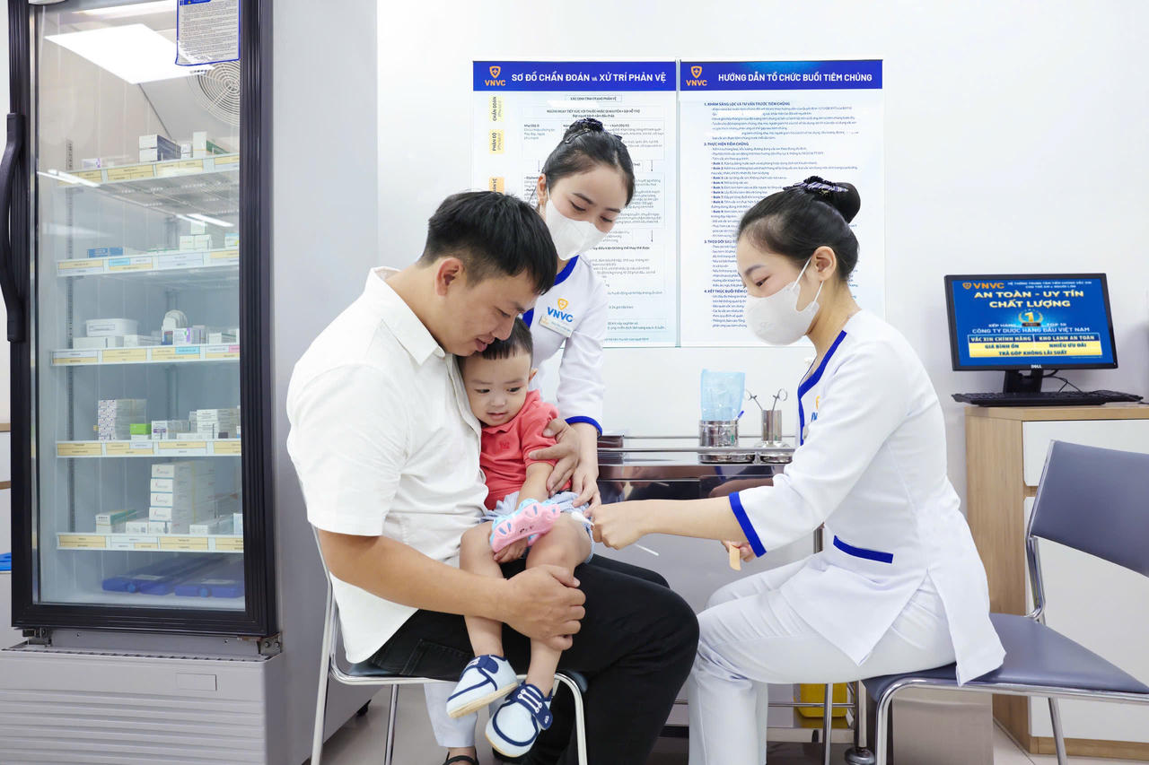 Anh Quý đưa con trai Minh Đức, 23 tháng tuổi đến VNVC tiêm vắc xin tay chân miệng, ngày 25-9. Ảnh: Nhân Lê