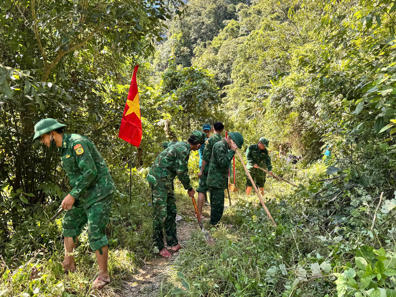 Cán bộ, chiến sĩ Đồn Biên phòng Hướng Phùng phát quang, mở lối trên tuyến đường bị hư hỏng. (Ảnh: BĐBP Quảng Trị)