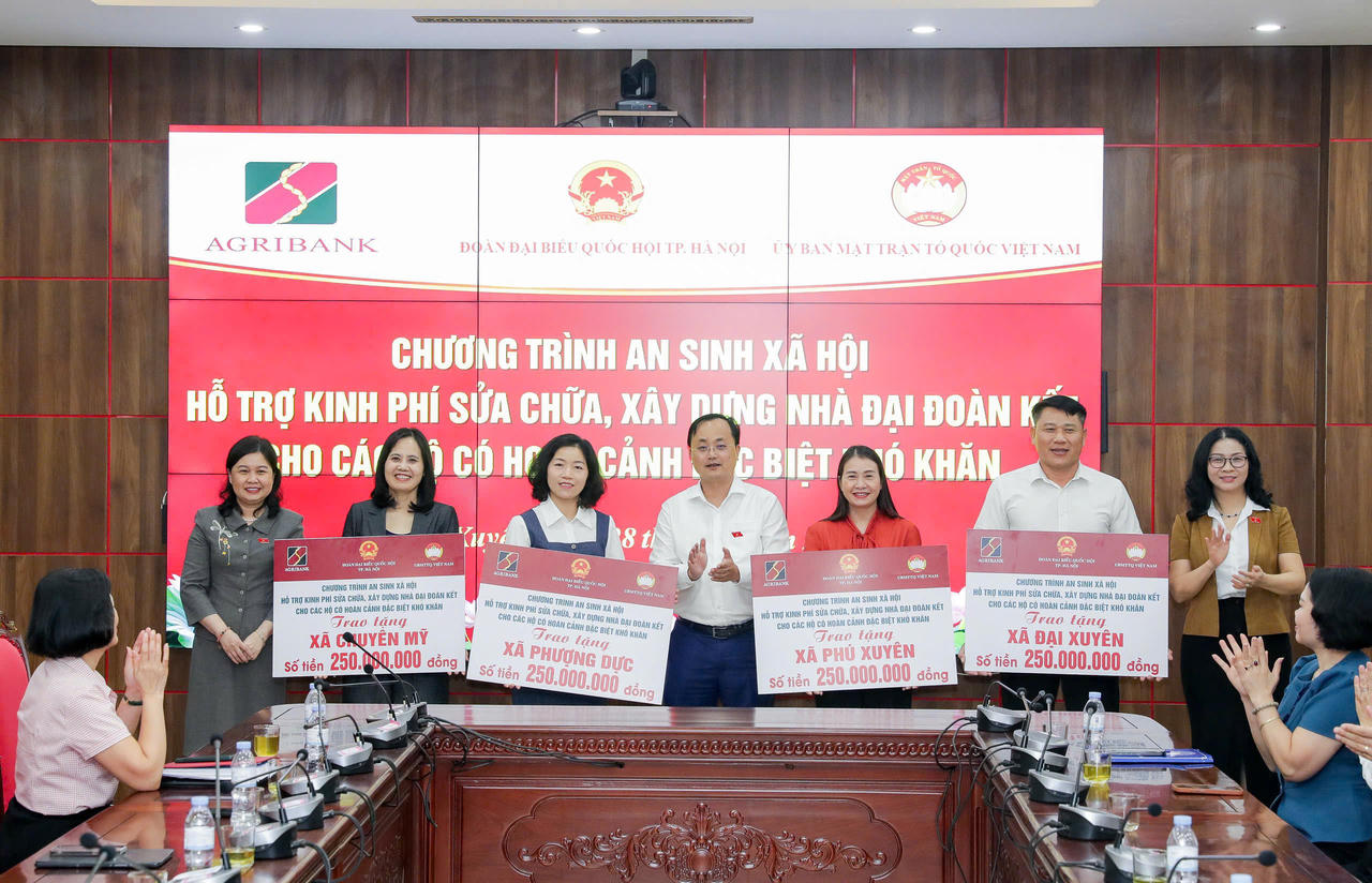 Đồng chí Tô Huy Vũ trao biểu trưng 1 tỷ đồng của Agribank hỗ trợ sửa chữa, xây dựng Nhà Đại đoàn kết cho các hộ gia đình có hoàn cảnh đặc biệt khó khăn tại 4 xã Phú Xuyên, Chuyên Mỹ, Phượng Dực và Đại Xuyên