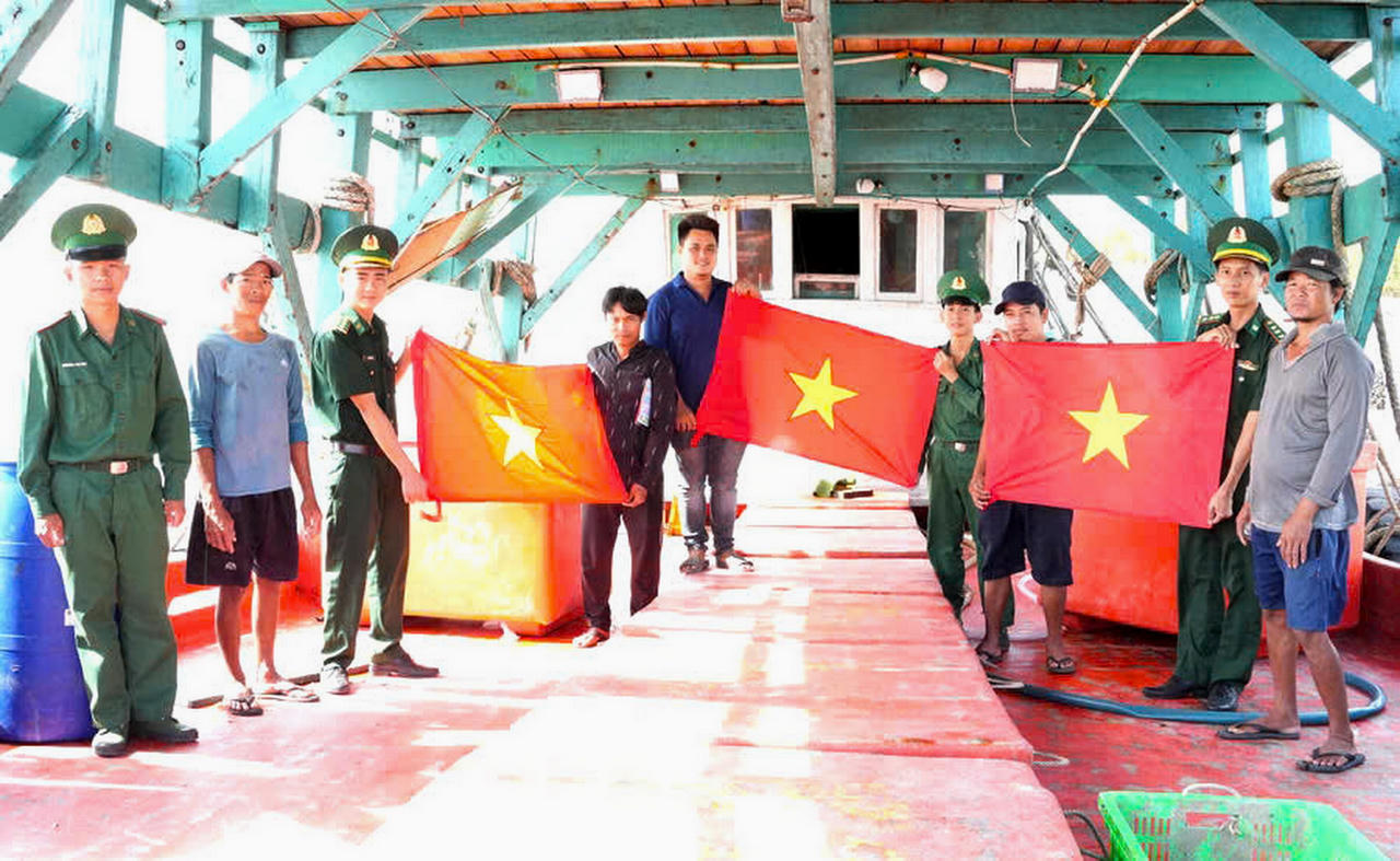 Cán bộ Đồn BP Rạch Gốc tuyên truyền pháp luật, trao tặng cờ Tổ quốc cho ngư dân, tiếp thêm động lực để bà con vươn khơi bám biển, tham gia bảo vệ chủ quyền biển, đảo (Ảnh: T.N).