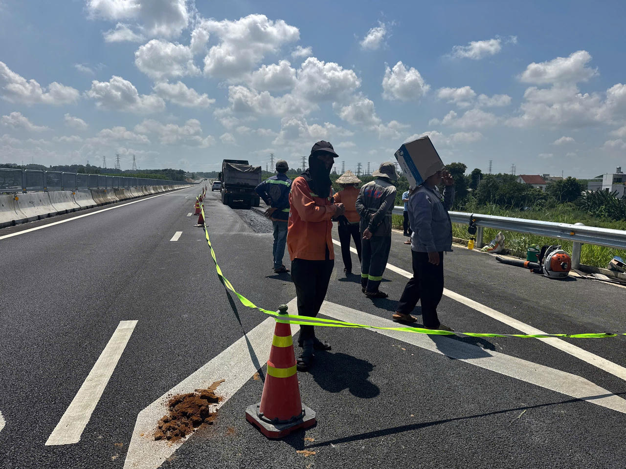 Công nhân cắt, bóc lớp bê tông nhựa tại vị trí mặt đường cao tốc Biên Hòa - Vũng Tàu xuất hiện lún, nứt. Ảnh: DK