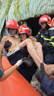 Cán bộ, chiến sĩ PCCC và CNCH phối hợp đưa người bị nạn ra khỏi nơi nguy hiểm.