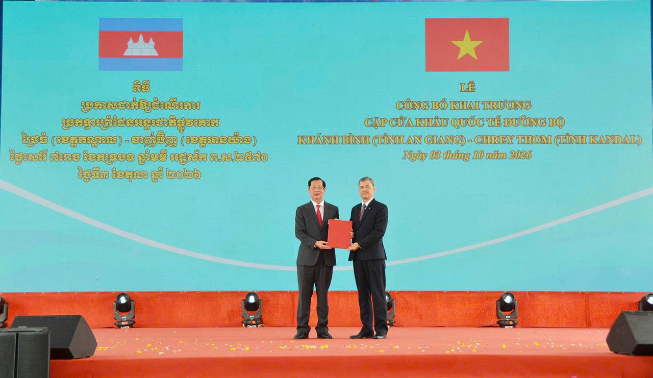 Ông Nguyễn Hoàng Hải, Phó chủ nhiệm Ủy ban Biên giới quốc gia, Bộ Ngoại giao (bên phải), trao Nghị quyết của Chính phủ cho ông Lê Văn Phước, Phó Chủ tịch UBND tỉnh An Giang. Ảnh: Khánh Thùy