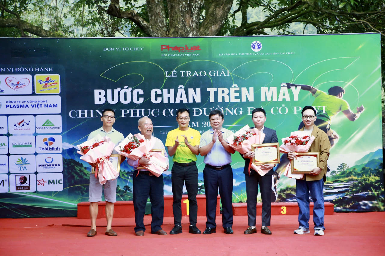 Ông Trần Mạnh Hùng - Giám đốc Sở Văn hóa, Thể thao và Du lịch tỉnh Lai Châu và Nhà báo Trần Ngọc Hà - Phó Tổng Biên tập Báo Pháp luật Việt Nam tặng hoa các đơn vị đồng hành và nhà tài trợ. (Ảnh: Hữu Trường)