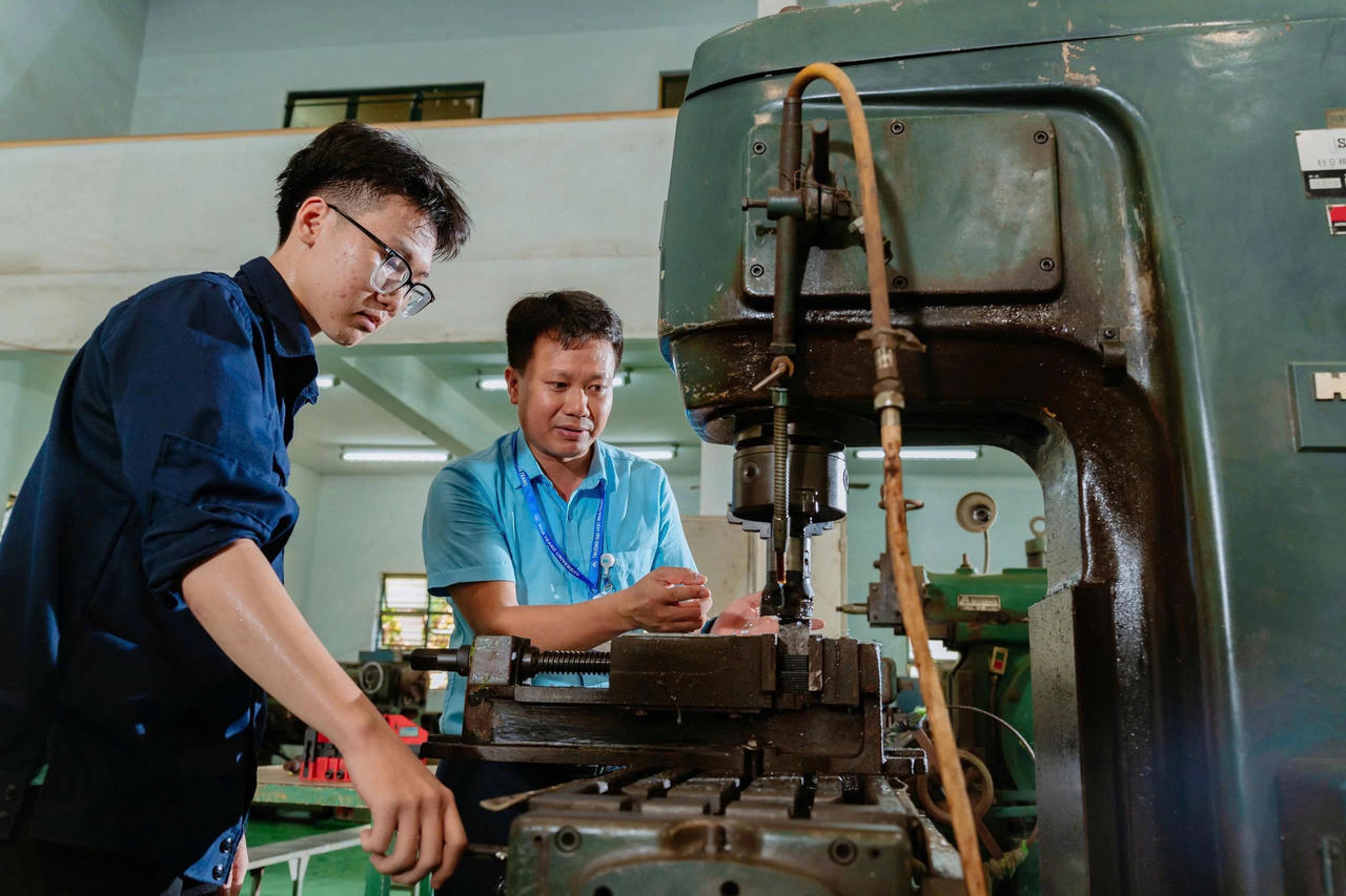 Giảng viên hướng dẫn sinh viên thực hành vận hành máy gia công cơ khí tại xưởng thực hành Trường Kỹ thuật và công nghệ, Trường Đại học Nha Trang. Ảnh: NTU