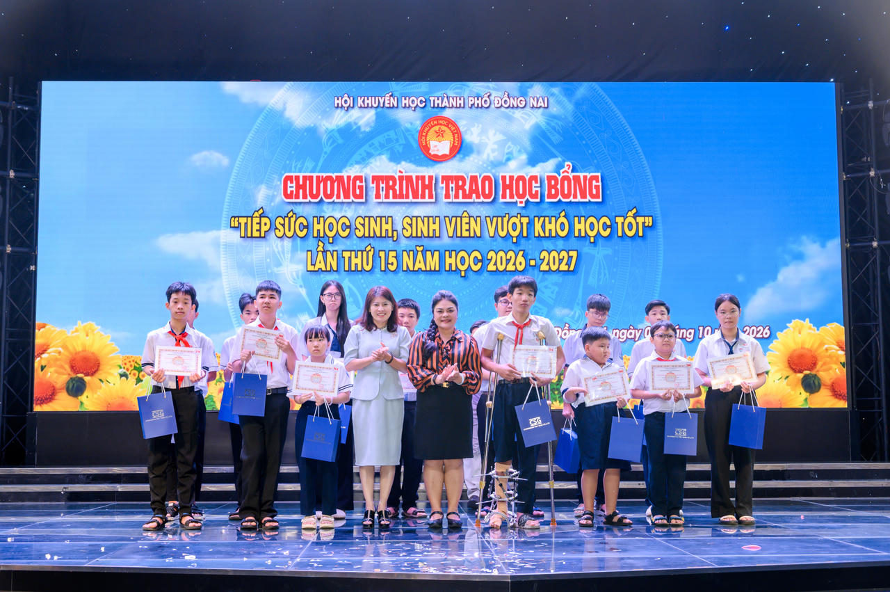 Bà Nguyễn Thu Thủy - Phó Giám đốc Đối ngoại Vedan Việt Nam (áo cam đen) trao học bổng “Tiếp sức học sinh, sinh viên vượt khó học tốt” cho các em.