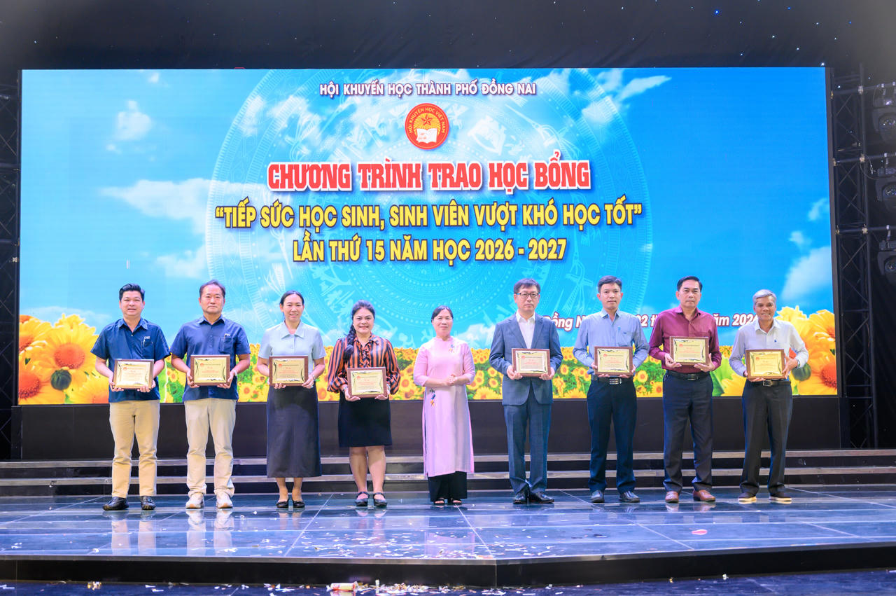 Ban tổ chức trao bảng tri ân cho đại diện Vedan Việt Nam (áo cam đen).