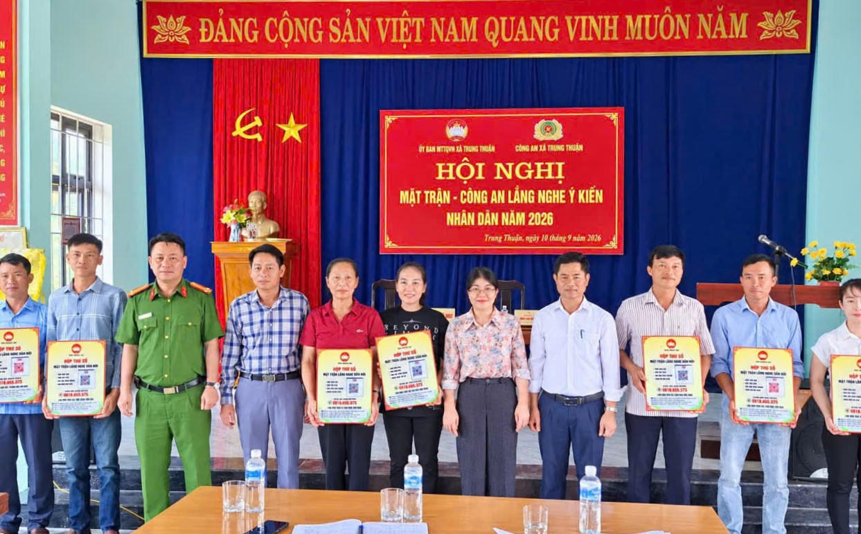 Đại diện Công an xã Trung Thuần và Ủy ban MTTQ Việt Nam xã trao bảng thông tin đường dây nóng tiếp nhận phản ánh, kiến nghị của Nhân dân tại hội nghị “Mặt trận - Công an lắng nghe ý kiến Nhân dân”. (Ảnh: M.P)