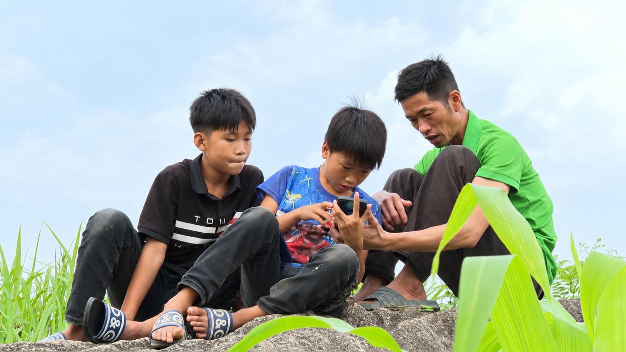 Ông Và nhờ cháu trai (áo xanh) hướng dẫn gọi điện cho con trai