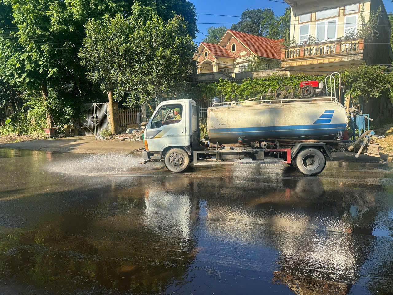 Đơn vị vận chuyển bố trí phương tiện tưới nước, rửa đường tại những khu vực thường xuyên có xe tải qua lại (Ảnh: Nguyễn Hải).