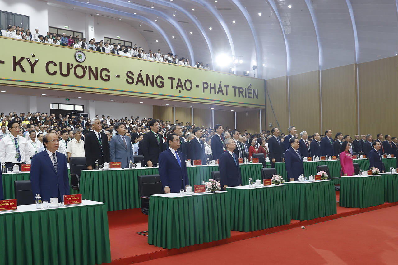 Các đại biểu tham dự Lễ kỷ niệm thực hiện nghi thức chào cờ. 