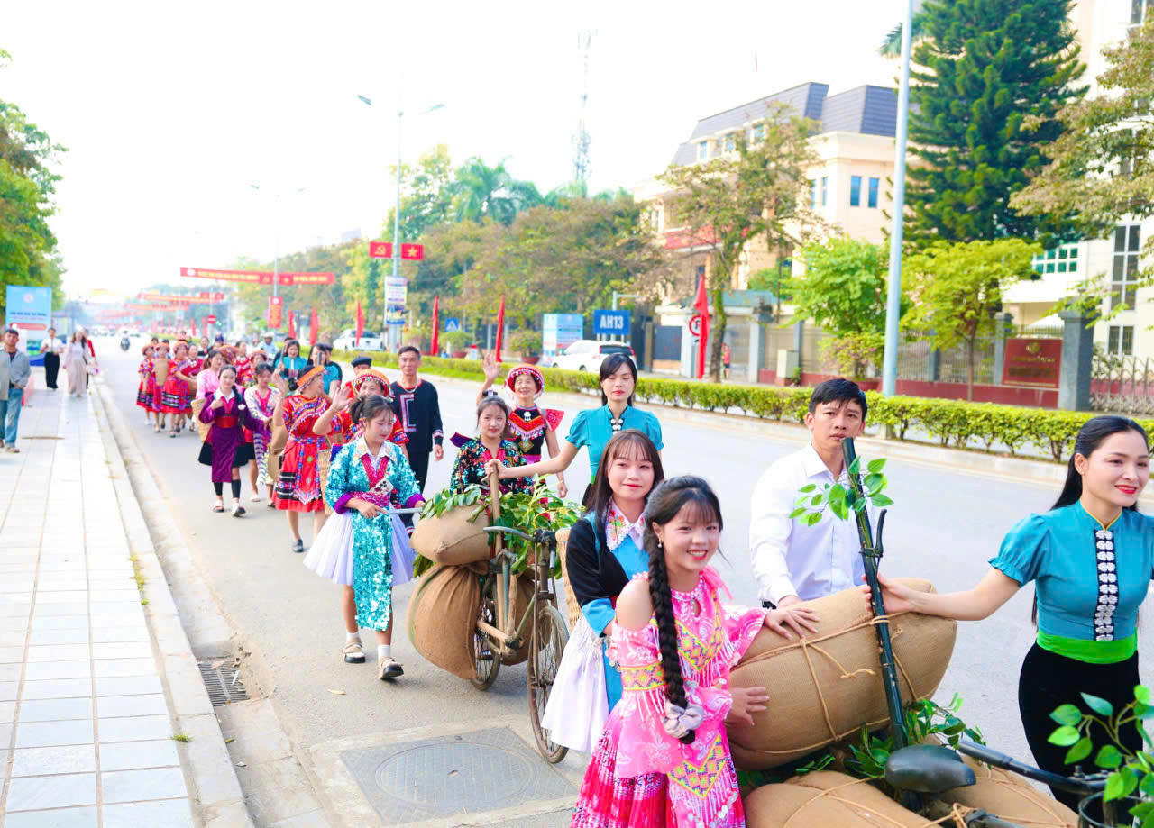 Người dân và du khách trong trang phục truyền thống của đồng bào Mông, Thái tham gia trải nghiệm đẩy xe đạp thồ trên đường Võ Nguyên Giáp.