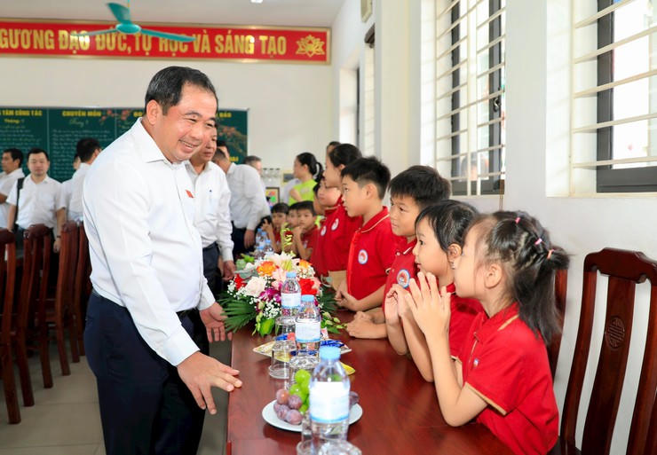Bí thư Thành ủy Hà Nội Trần Đức Thắng trò chuyện thân mật cùng học sinh Trường Tiểu học Thiên Đức, xã Phù Đổng (Ảnh: Hanoi.gov.vn)