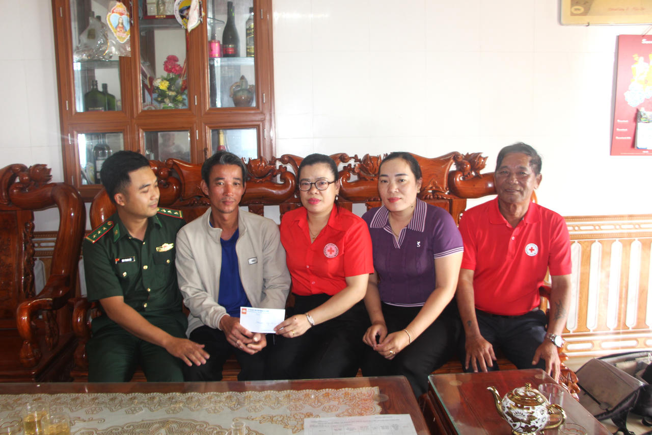 Cán bộ biên phòng và đại diện Hội Chữ thập đỏ địa phương hỗ trợ, động viên anh Cường cùng gia đình vượt qua khó khăn sau tai nạn. (Ảnh: Minh Phương)