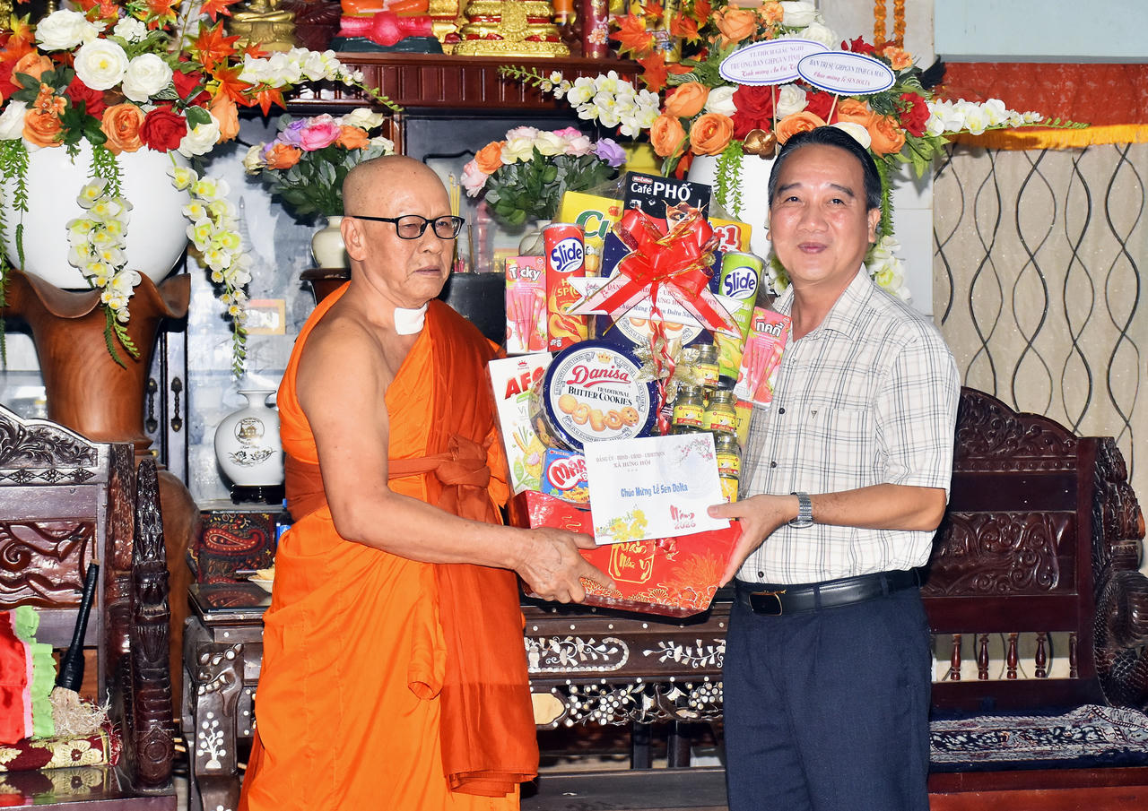 Ông Từ Minh Phúc - Bí thư Đảng ủy xã Hưng Hội trao quà đến Hòa thượng Hữu Hinh, cùng Ban Quản trị chùa Cù Lao (Ảnh: T.N).