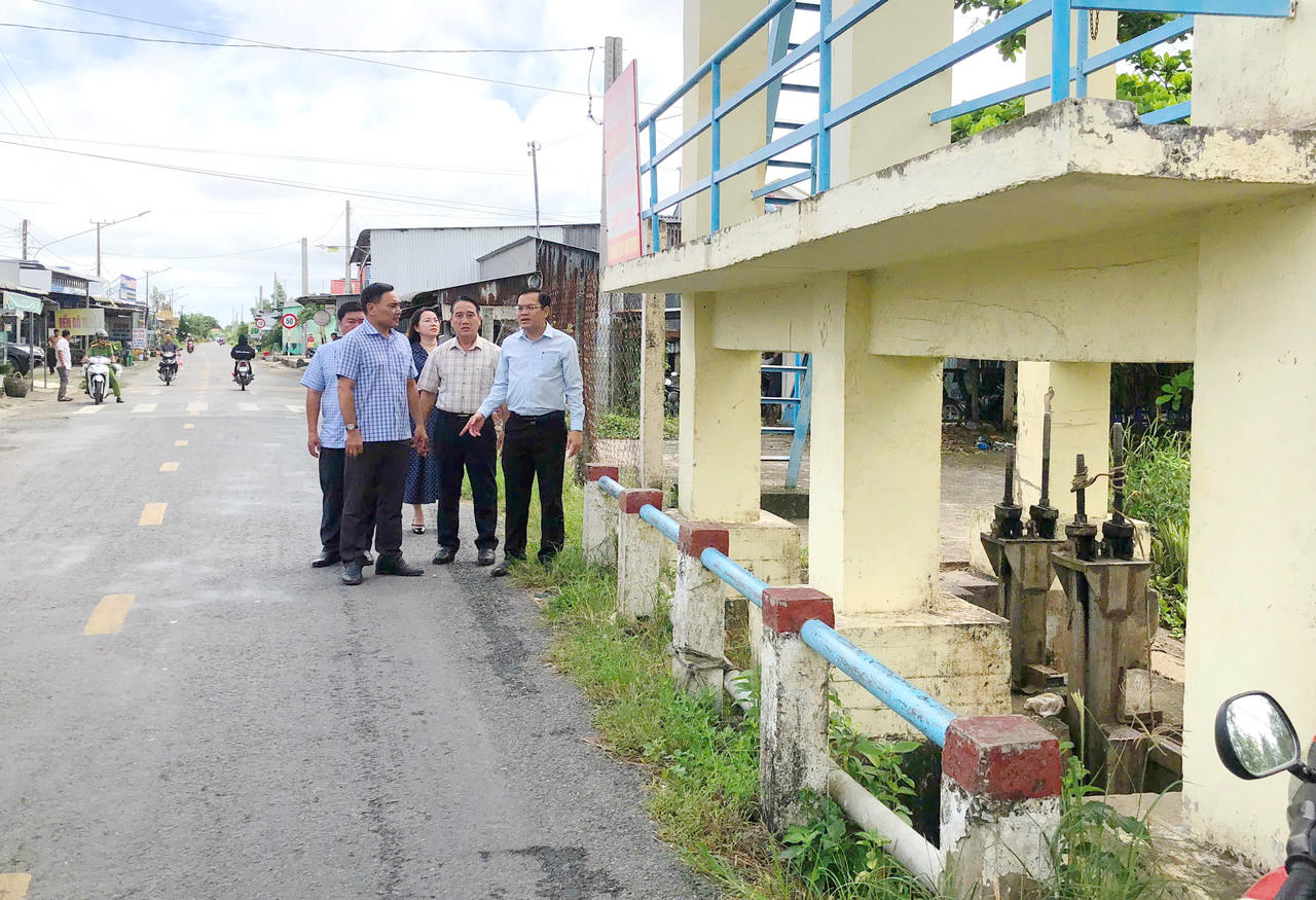 Phó Chủ tịch UBND tỉnh Cà Mau Ngô Vũ Thăng (hàng đầu, bên phải), kiểm tra tiến độ thi công các hạng mục cống ngăn mặn trên địa bàn xã Hưng Hội (Ảnh: T.N).