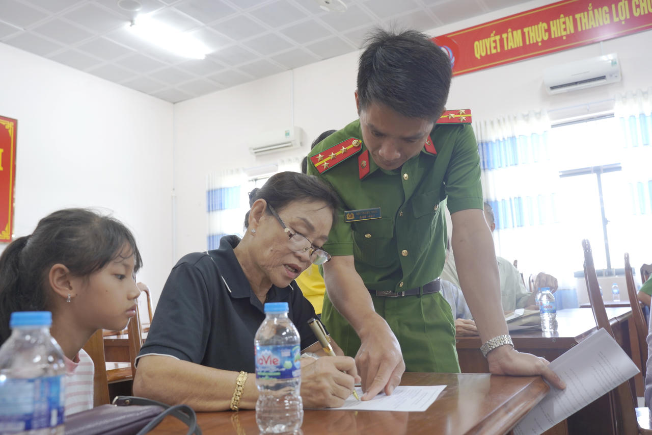 Cán bộ Công an xã, phường hướng dẫn thân nhân liệt sĩ kê khai thông tin trước khi lấy mẫu ADN (Ảnh: H.Đ).