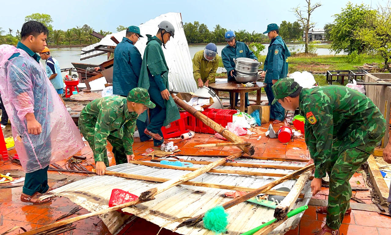 Cán bộ, chiến sĩ Đồn BP Khánh Tiến phối hợp với chính quyền, người dân địa phương khắc phục hậu quả dông lốc làm sập nhà dân (Ảnh: BĐBP).