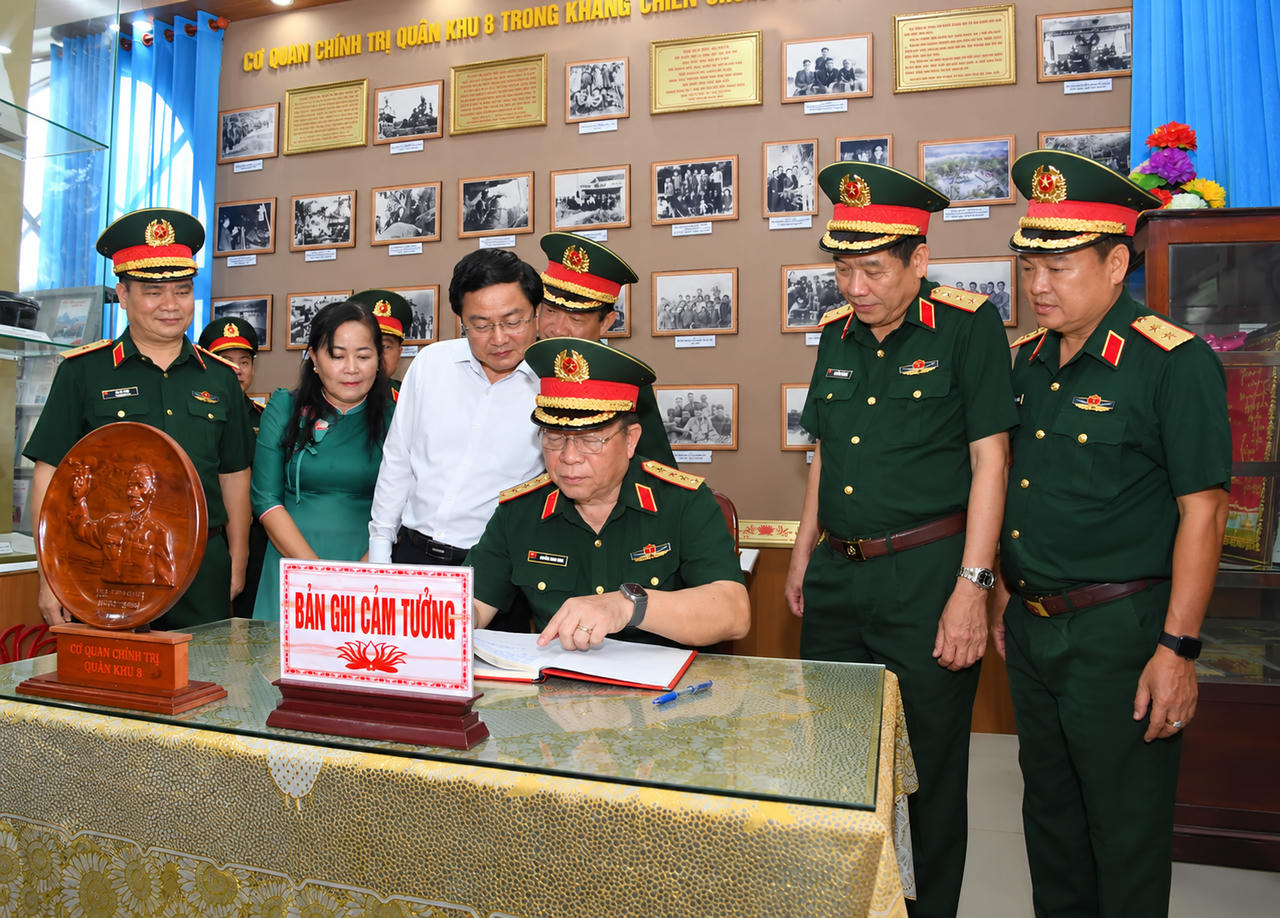 Đại tướng Nguyễn Trọng Nghĩa ghi cảm tưởng tại Nhà truyền thống Cơ quan Chính trị Quân khu 8. Ảnh: QK7