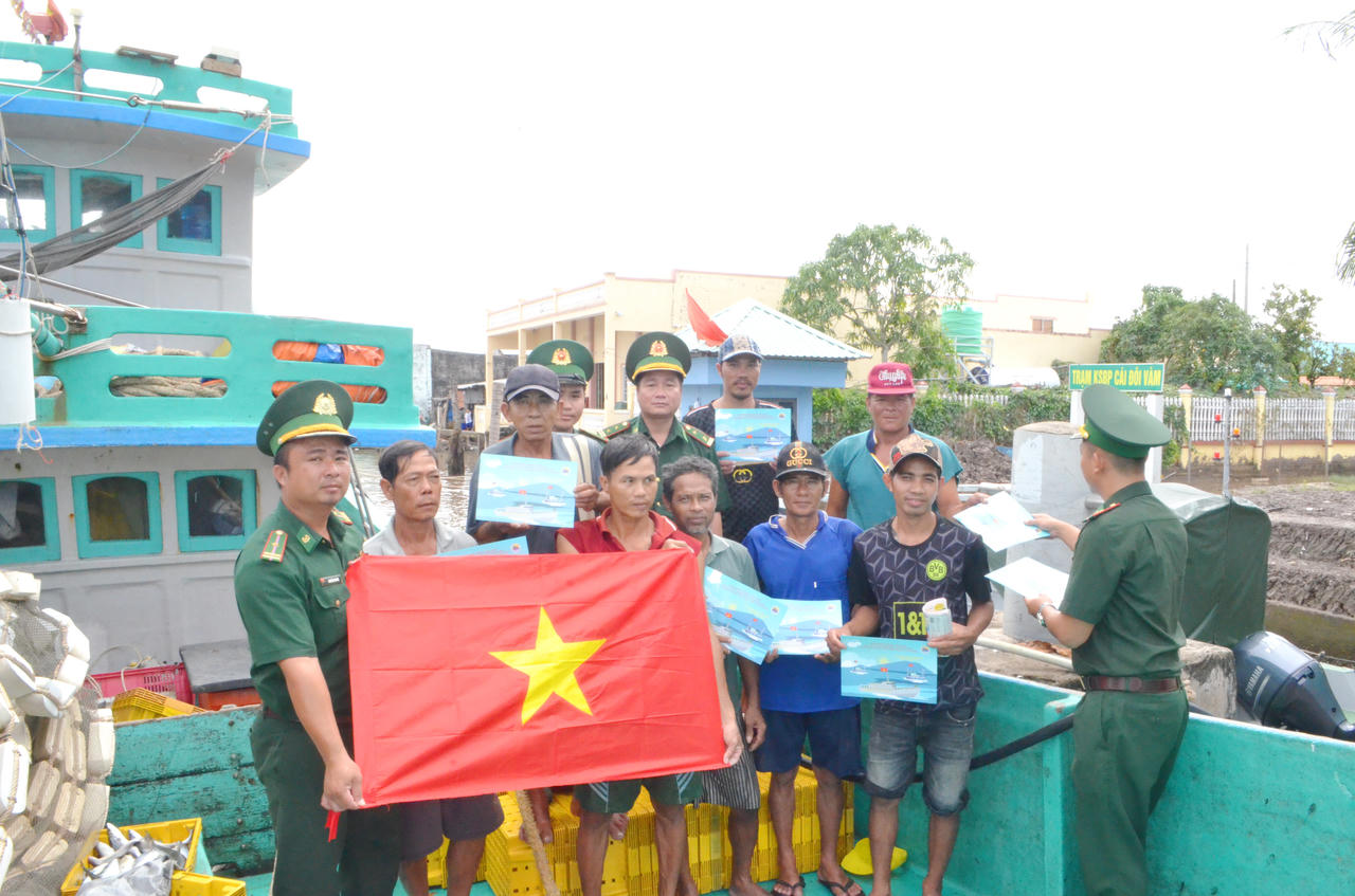 Cán bộ, chiến sĩ Biên phòng Cái Đôi Vàm tuyên truyền, tặng cờ Tổ quốc, vận động ngư dân tham gia bảo vệ chủ quyền biển, đảo (Ảnh: T.N).