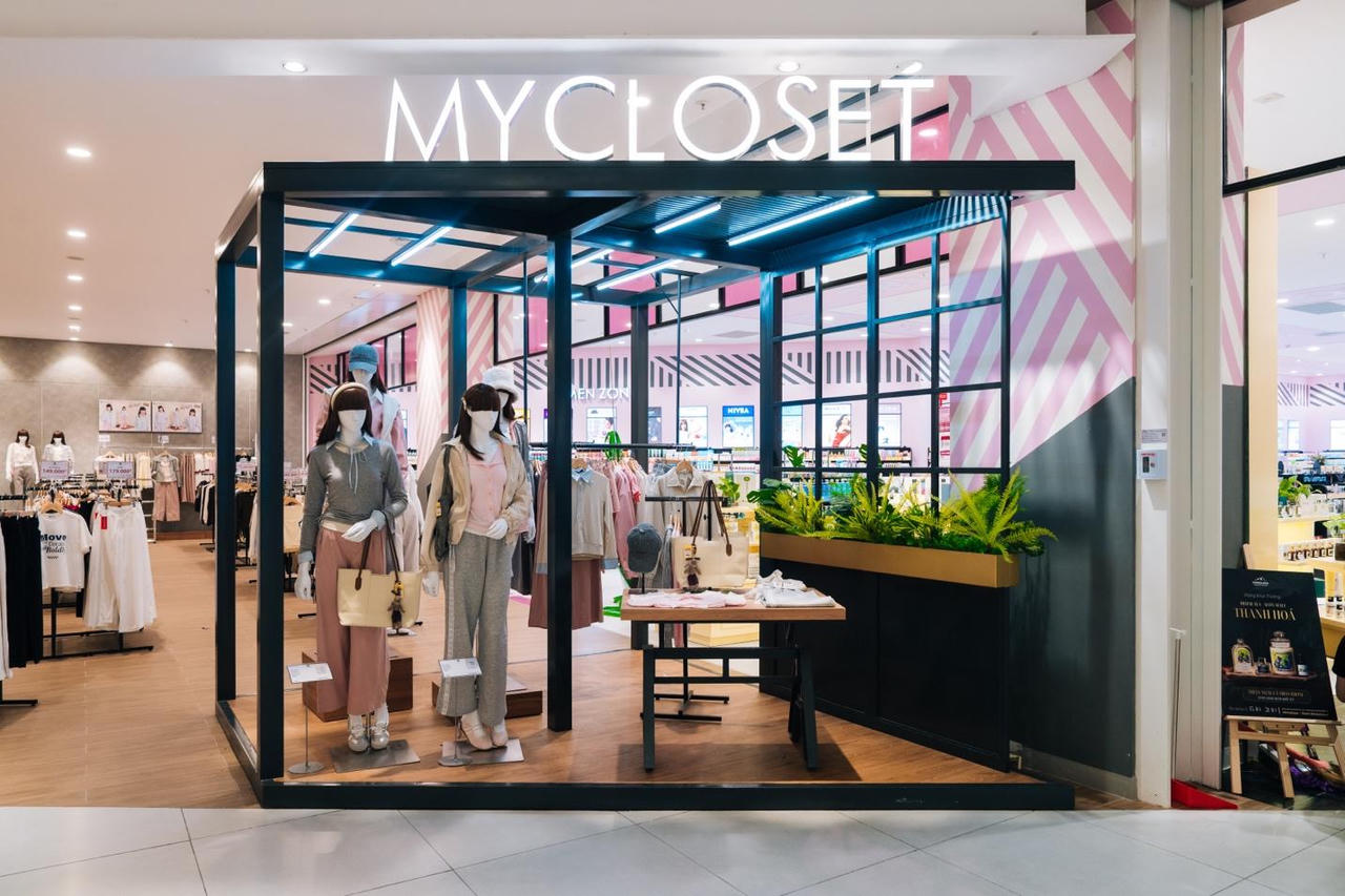 A storefront with mannequins in front of a sign

Description automatically generated
