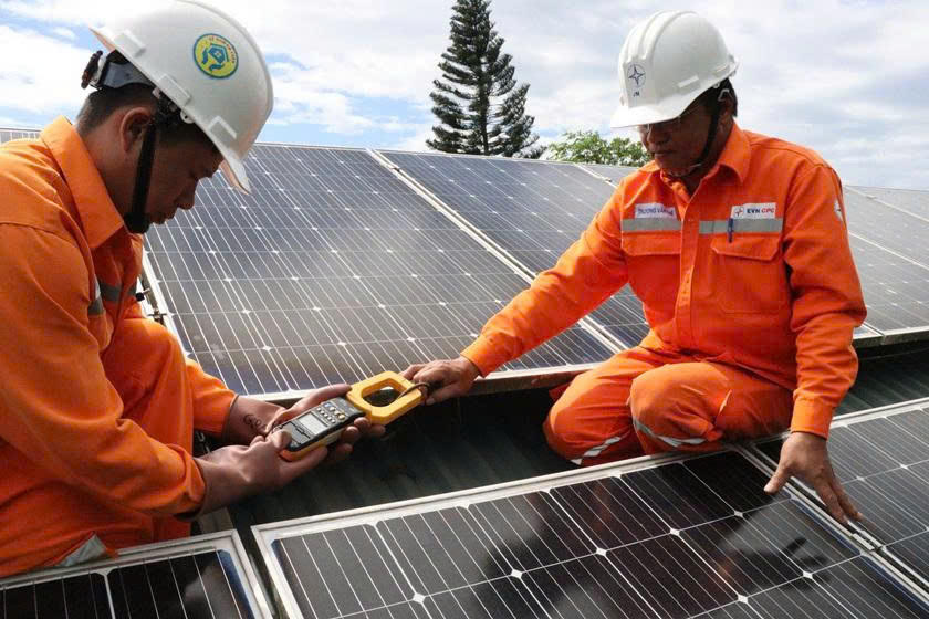 Nhân viên điện lực kiểm tra các tấm pin, bảo đảm hệ thống điện mặt trời mái nhà vận hành an toàn, hiệu quả. (Ảnh: H.N)