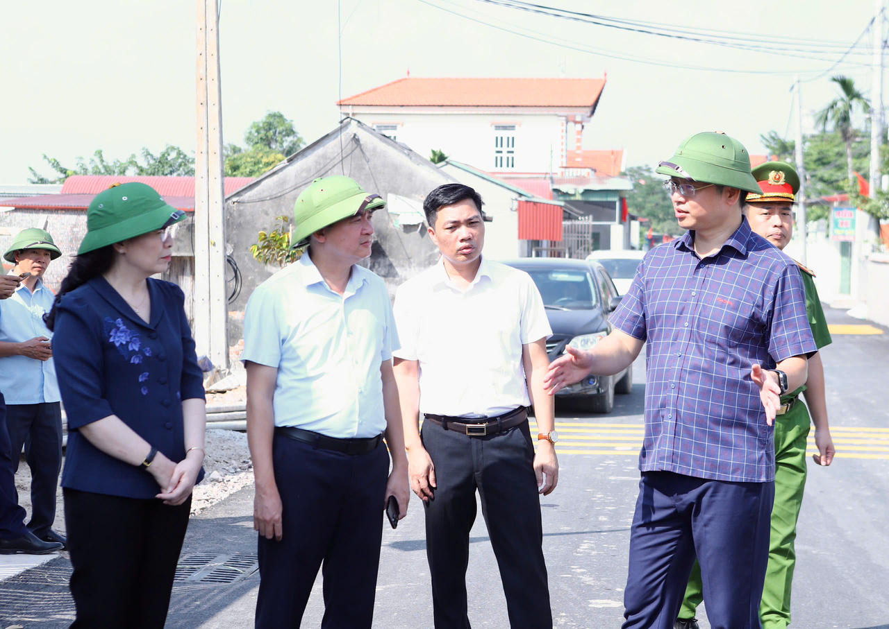 Phó Bí thư Thành ủy Trần Huy Phương và đoàn kiểm tra thực tế việc mở rộng đường giao thông tại xã Trung Chính. (Ảnh NH)